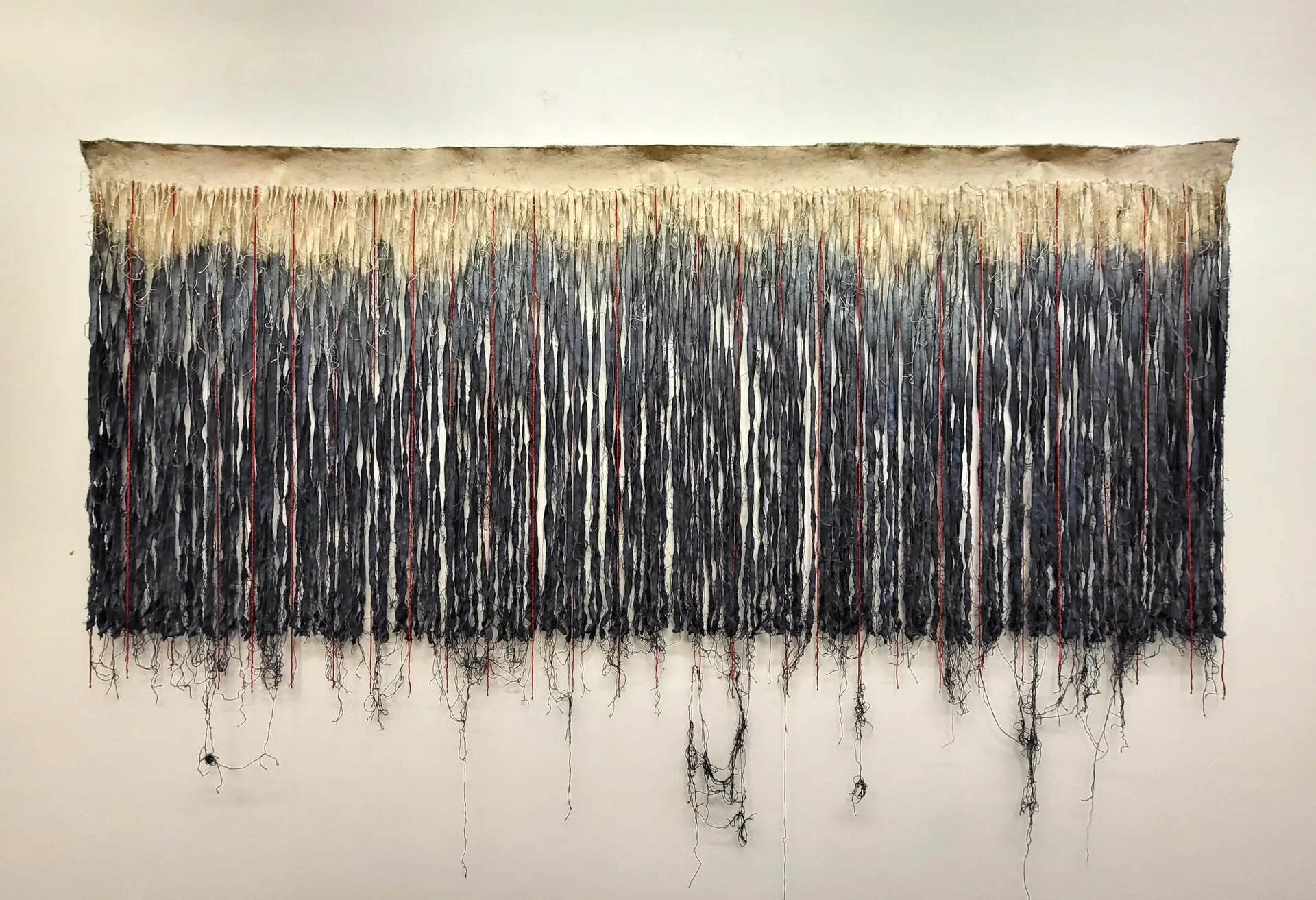 Seven-foot by three-foot piece of canvas, split into two colors tan and black, and a frayed fringe.