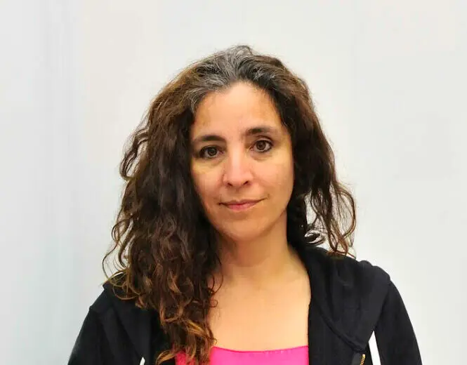 An image of Beatriz Santiago Muñoz wearing a black hoodie with hands in pockets looking directly at the camera.